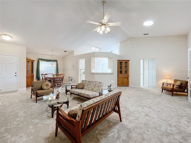 living room with a textured ceiling, ceiling fan with notable chandelier, light colored carpet, and vaulted ceiling