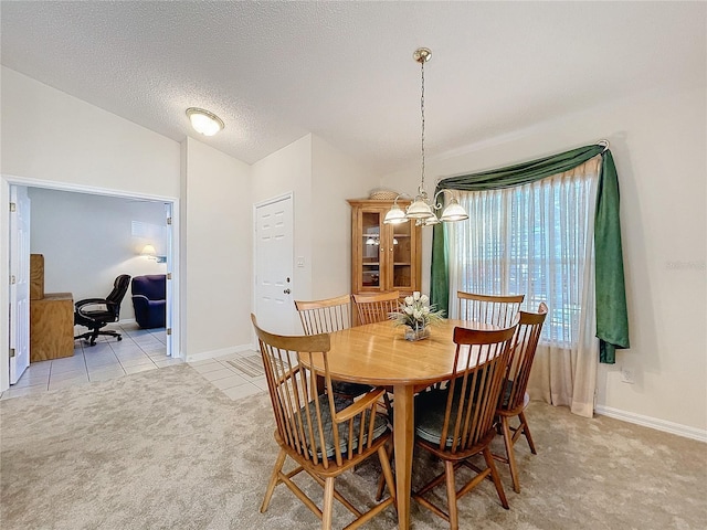 carpeted dining room featuring a textured ceiling, a chandelier, and lofted ceiling