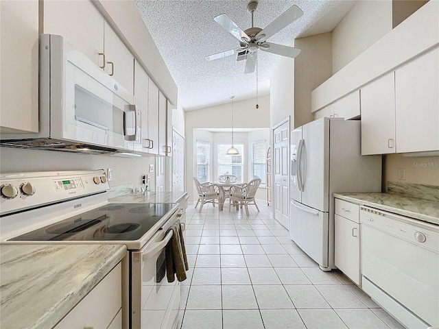 kitchen with a textured ceiling, white cabinets, vaulted ceiling, and white appliances