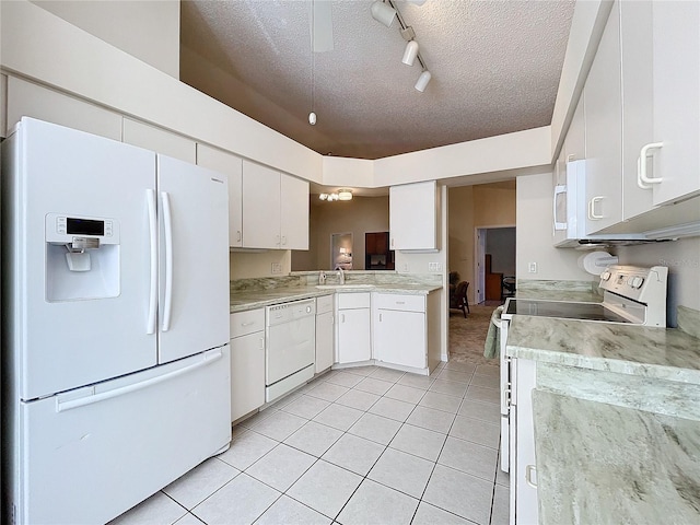 kitchen featuring white appliances, track lighting, light tile patterned floors, a textured ceiling, and white cabinetry