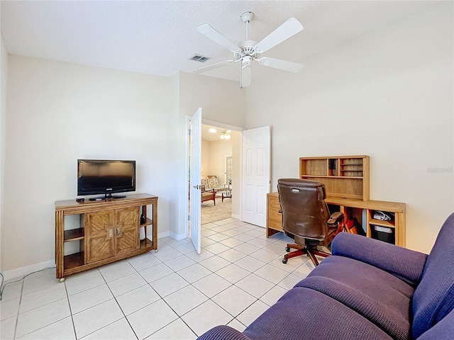 tiled office space with ceiling fan and a textured ceiling