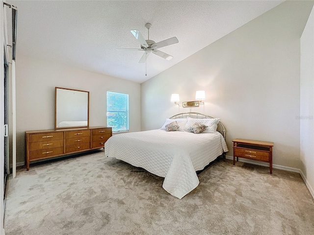 bedroom with a textured ceiling, light colored carpet, vaulted ceiling, and ceiling fan