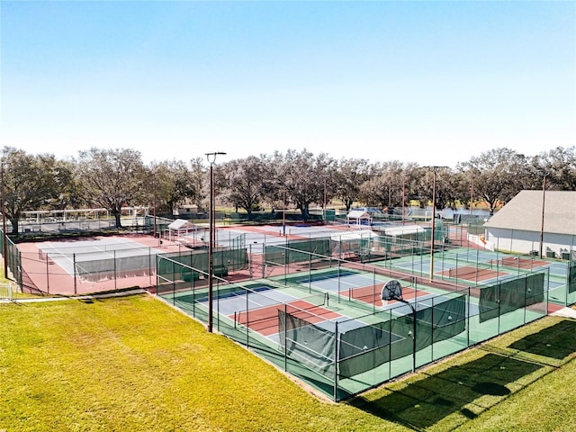 view of tennis court with a lawn