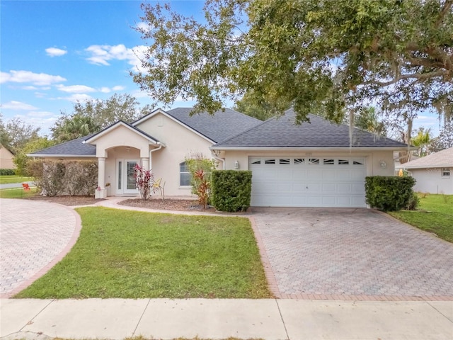 single story home featuring a front yard and a garage