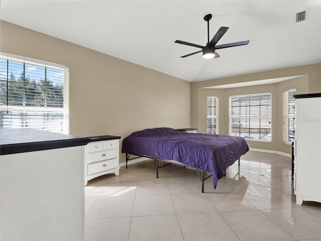 bedroom with vaulted ceiling, ceiling fan, and light tile patterned floors