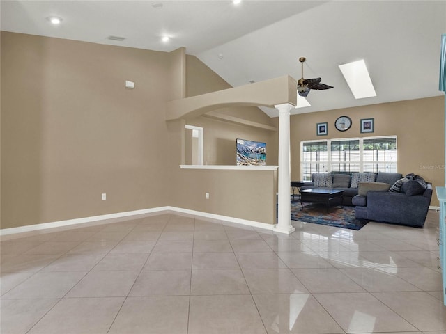 unfurnished living room with ornate columns, vaulted ceiling, ceiling fan, and light tile patterned floors