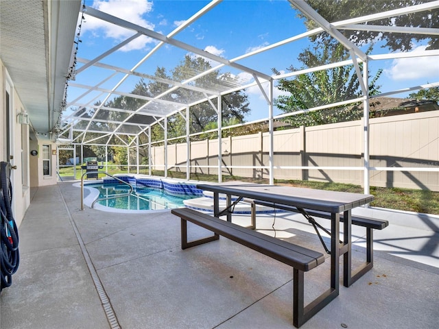 view of swimming pool featuring a patio and glass enclosure