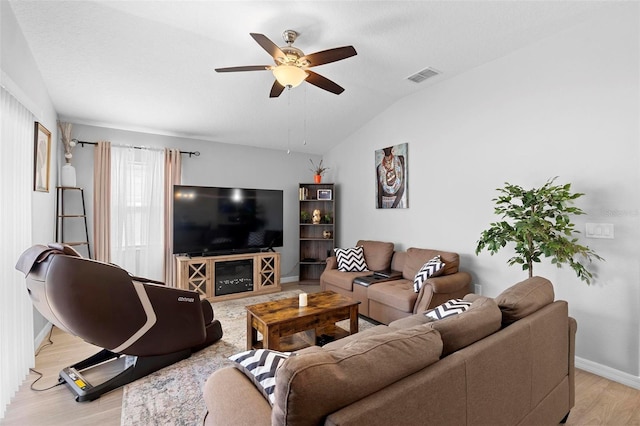 living room with ceiling fan, light hardwood / wood-style flooring, and lofted ceiling