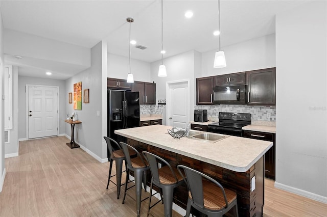 kitchen featuring black appliances, decorative light fixtures, and backsplash