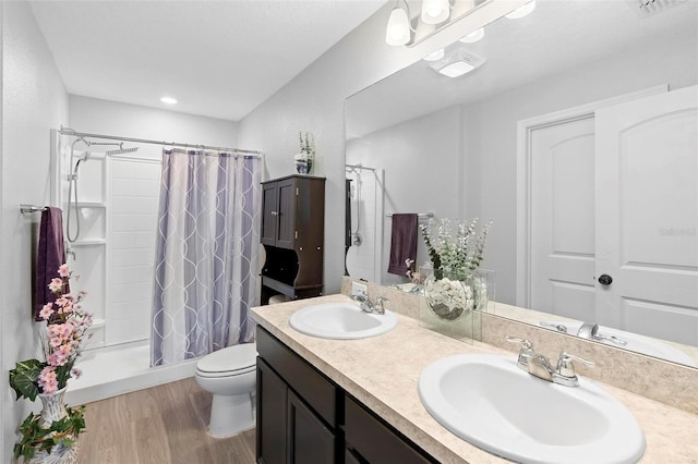 bathroom featuring vanity, toilet, wood-type flooring, and walk in shower