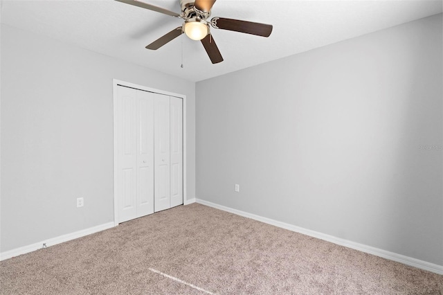 unfurnished bedroom featuring carpet, a closet, and ceiling fan