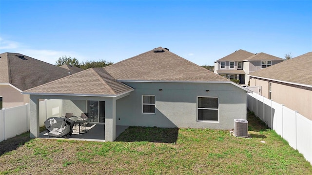 back of house with a patio, cooling unit, a shingled roof, stucco siding, and a lawn