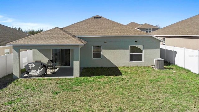 rear view of property with central AC unit, a patio, and a lawn