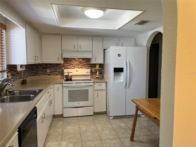 kitchen with tasteful backsplash, white appliances, a raised ceiling, sink, and white cabinets