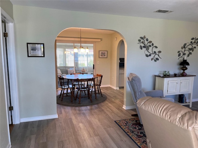 dining space featuring hardwood / wood-style floors and a notable chandelier