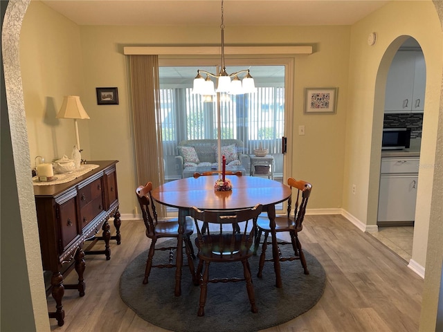 dining space with an inviting chandelier and light hardwood / wood-style flooring