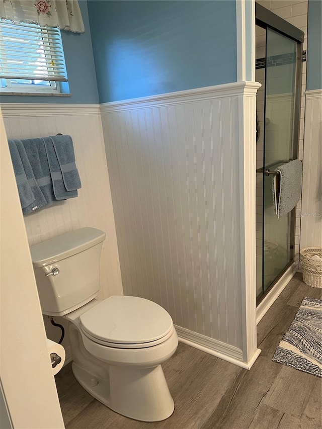 bathroom with hardwood / wood-style floors, toilet, and walk in shower