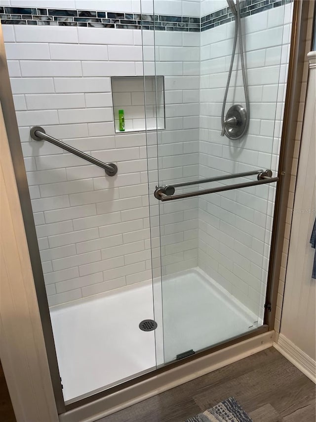 bathroom featuring wood-type flooring and walk in shower