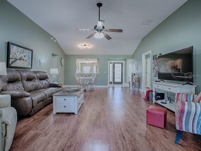 living room featuring ceiling fan, vaulted ceiling, and light hardwood / wood-style flooring