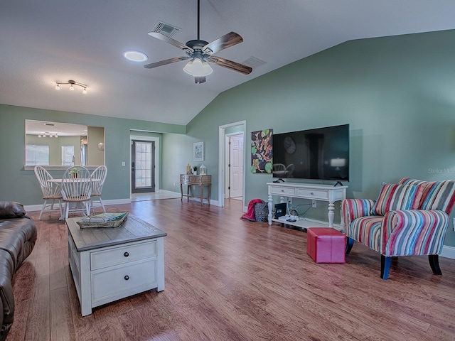 living room with ceiling fan, vaulted ceiling, and light hardwood / wood-style flooring