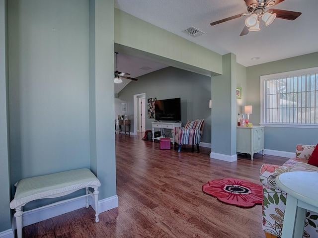 living room with ceiling fan, vaulted ceiling, and hardwood / wood-style flooring