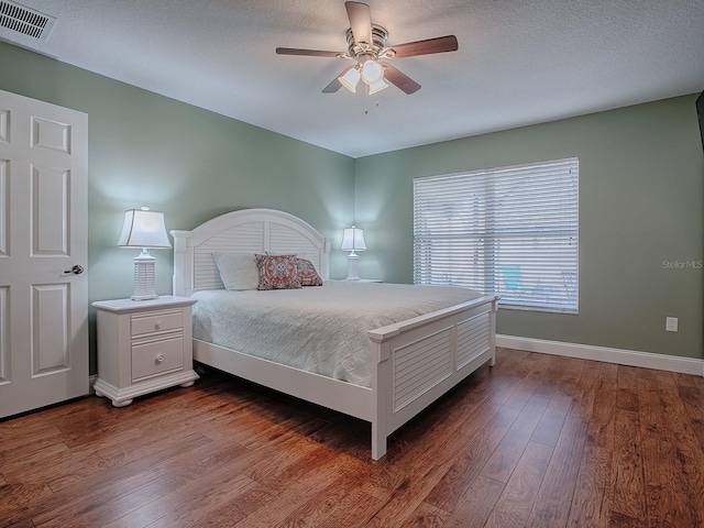 bedroom with ceiling fan, a textured ceiling, and hardwood / wood-style flooring