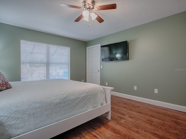 bedroom featuring a textured ceiling, ceiling fan, and hardwood / wood-style floors