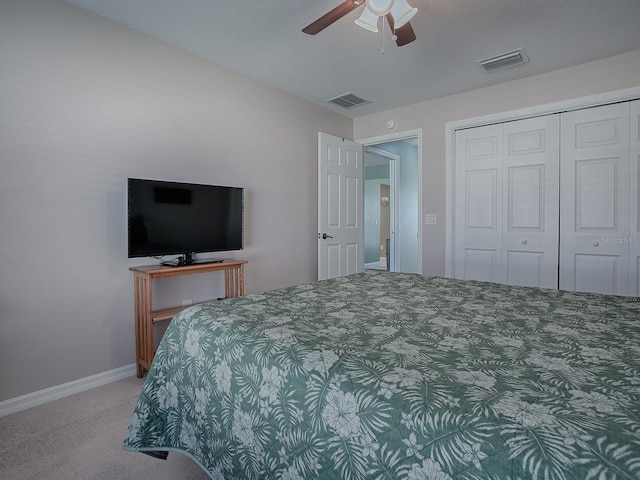 carpeted bedroom featuring ceiling fan and a closet