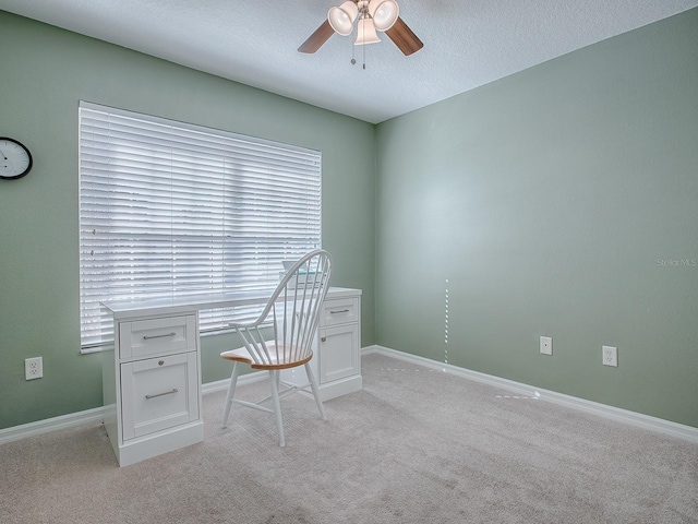 unfurnished office featuring ceiling fan, light colored carpet, and a textured ceiling