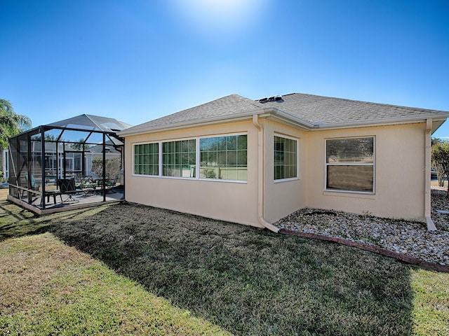 view of side of home with a patio area, a lanai, and a yard