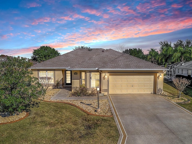 single story home featuring a garage and a yard