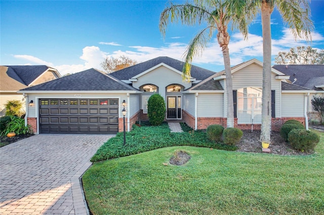 single story home with a garage and a front lawn