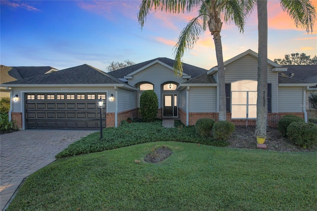 ranch-style house with a yard and a garage