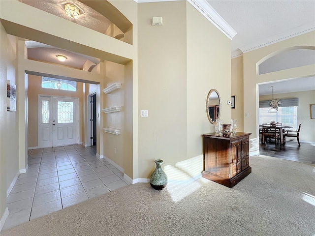 carpeted entrance foyer with crown molding