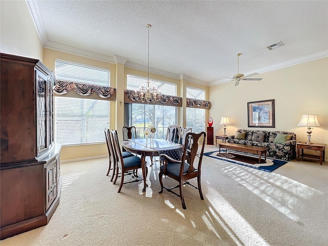 carpeted dining room featuring ceiling fan with notable chandelier, a textured ceiling, and ornamental molding