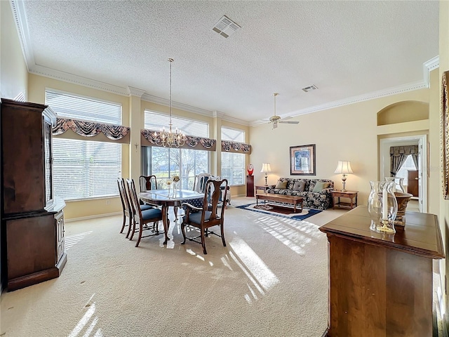 carpeted dining room featuring ceiling fan with notable chandelier, crown molding, and a textured ceiling