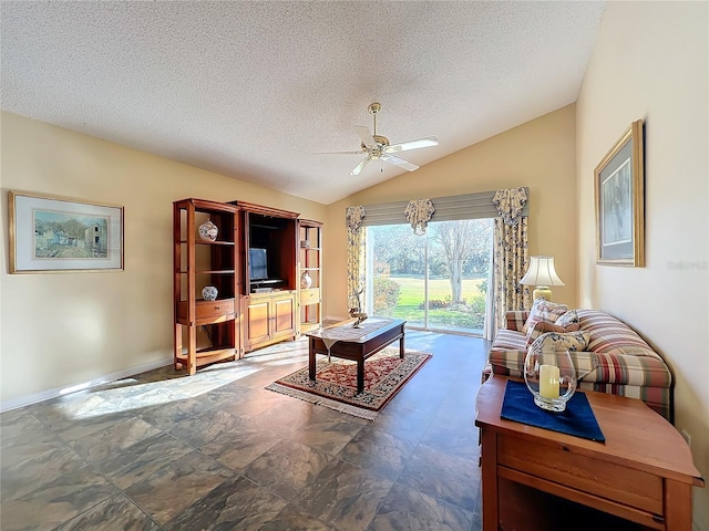 living room with lofted ceiling, ceiling fan, and a textured ceiling