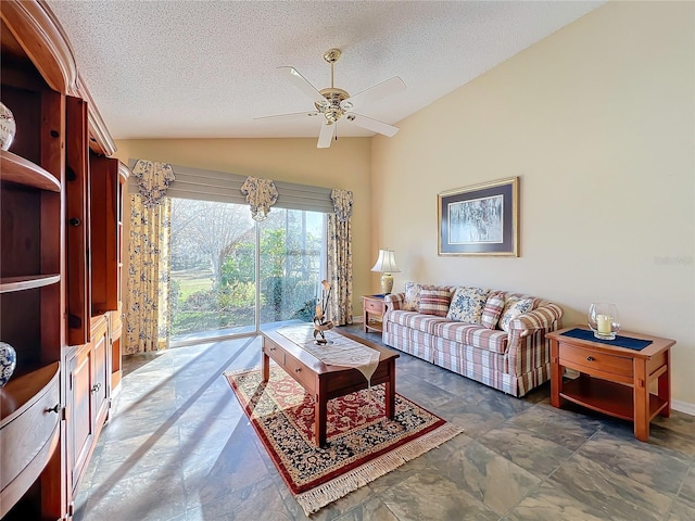 living room featuring ceiling fan, lofted ceiling, and a textured ceiling