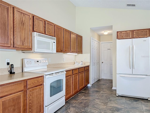 kitchen featuring lofted ceiling and white appliances