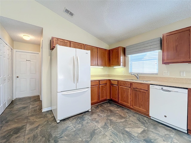 kitchen with a textured ceiling, white appliances, lofted ceiling, and sink