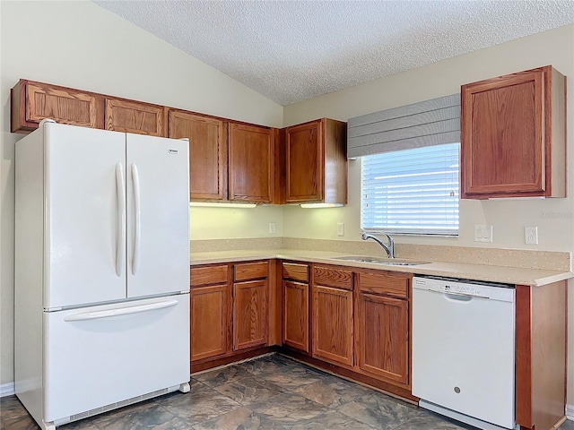 kitchen featuring a textured ceiling, lofted ceiling, white appliances, and sink