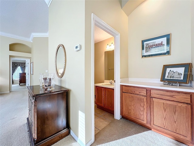 bathroom featuring vanity, ornamental molding, and a textured ceiling