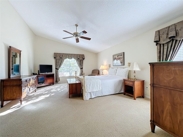 bedroom featuring light carpet, a textured ceiling, vaulted ceiling, and ceiling fan