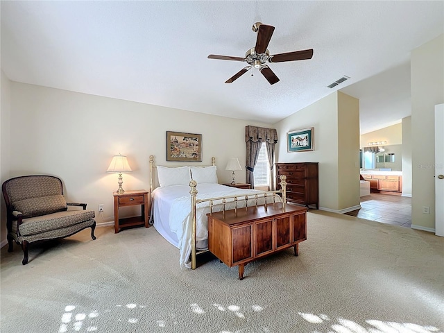 bedroom featuring ensuite bath, ceiling fan, light colored carpet, and lofted ceiling