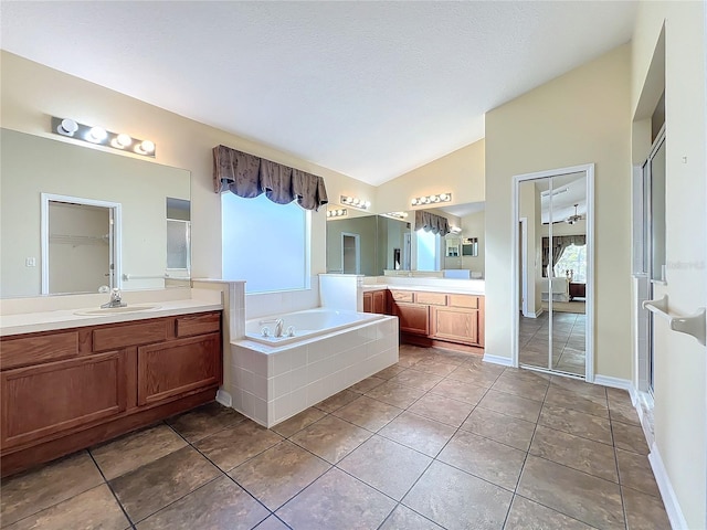 bathroom with ceiling fan, tile patterned flooring, lofted ceiling, vanity, and independent shower and bath