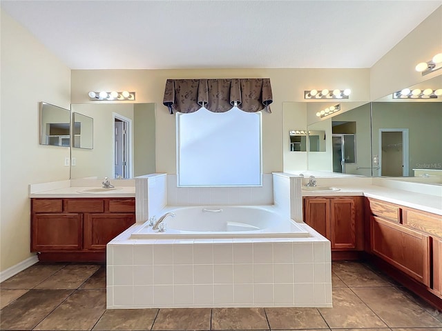 bathroom with tile patterned floors, vanity, and tiled tub