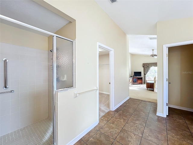 bathroom with ceiling fan, a shower with door, and tile patterned flooring