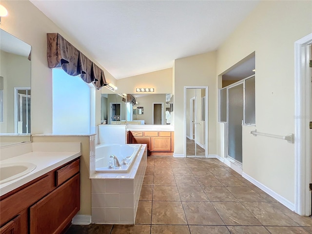 bathroom with tile patterned flooring, vanity, plus walk in shower, and vaulted ceiling