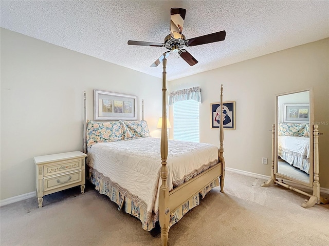 carpeted bedroom featuring ceiling fan and a textured ceiling