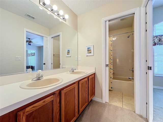 bathroom featuring tile patterned floors, vanity, a textured ceiling, shower / tub combo with curtain, and ceiling fan